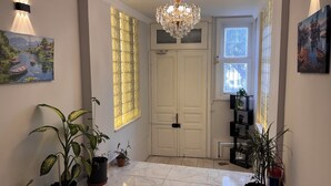 A hallway with a chandelier, a large window with a view, and several potted plants. - Disa Elite istanbul  (Istanbul)