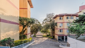 A residential area with multi-story buildings, a paved pathway, and greenery. - Fully Furnished Apartments in Florianopolis - OPT (Florianópolis)