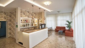 Una sala de estar moderna con una zona de bar, un conjunto de sofás y una mesa de centro.