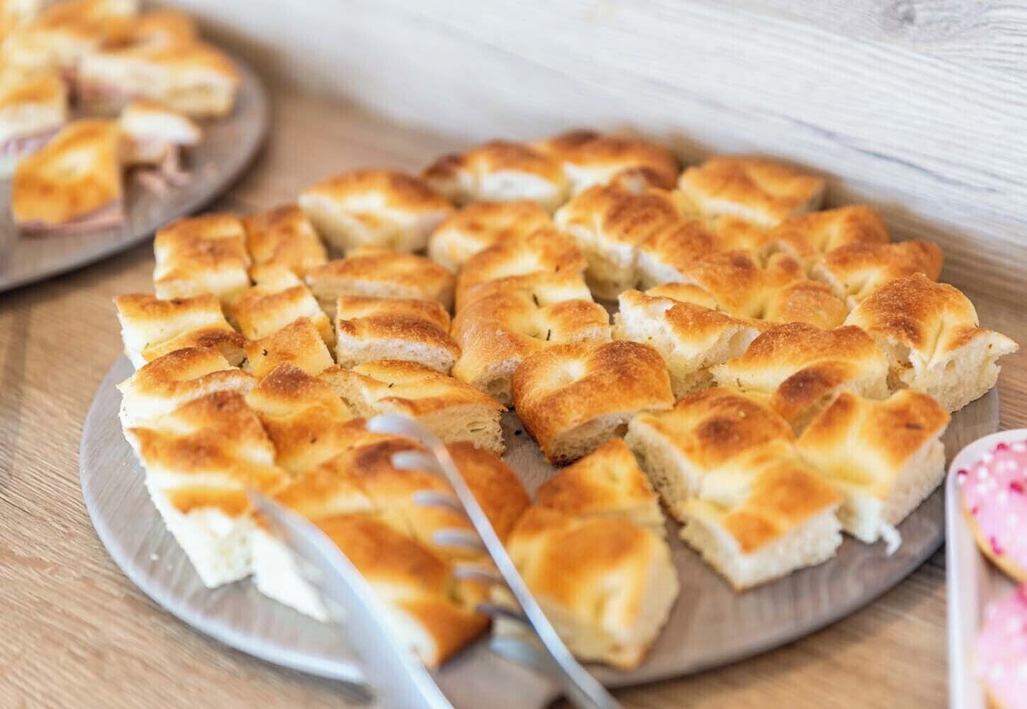 Une assiette de tranches de pain doré, disposées en cercle sur une table en bois.