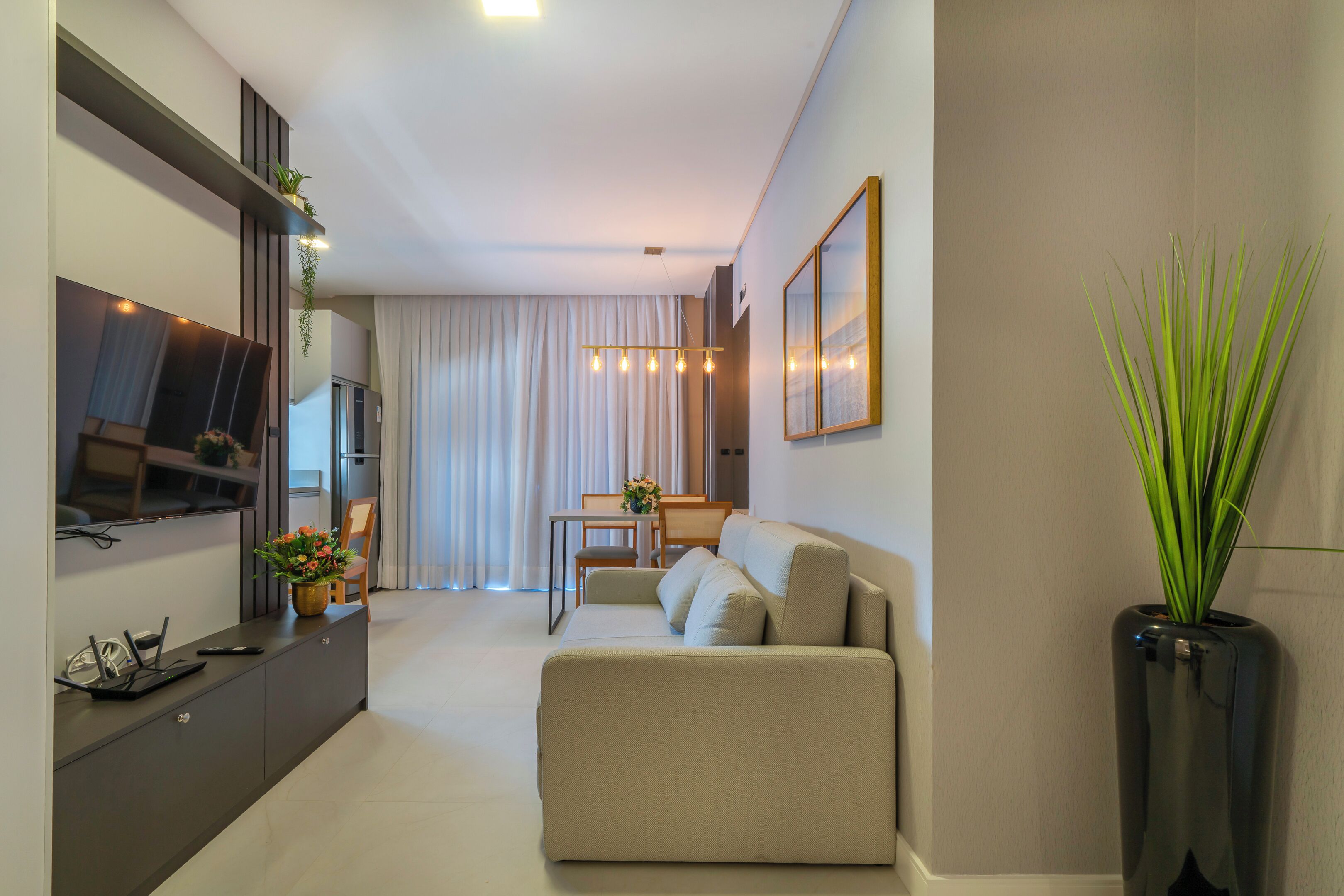 Una sala de estar moderna con un sofá, una mesa de comedor y un televisor.