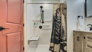 A bathroom with a shower, a toilet, a sink, and a cabinet.