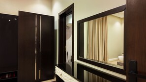 Un bagno moderno con un mobile lavabo in legno scuro, un grande specchio e una zona doccia a vista.