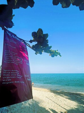 Ein Strand mit einem Schild, das Massagen anbietet.
