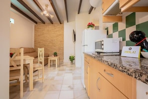 Una cocina moderna con microondas, cafetera y un cartel que dice 'HOLA!'.