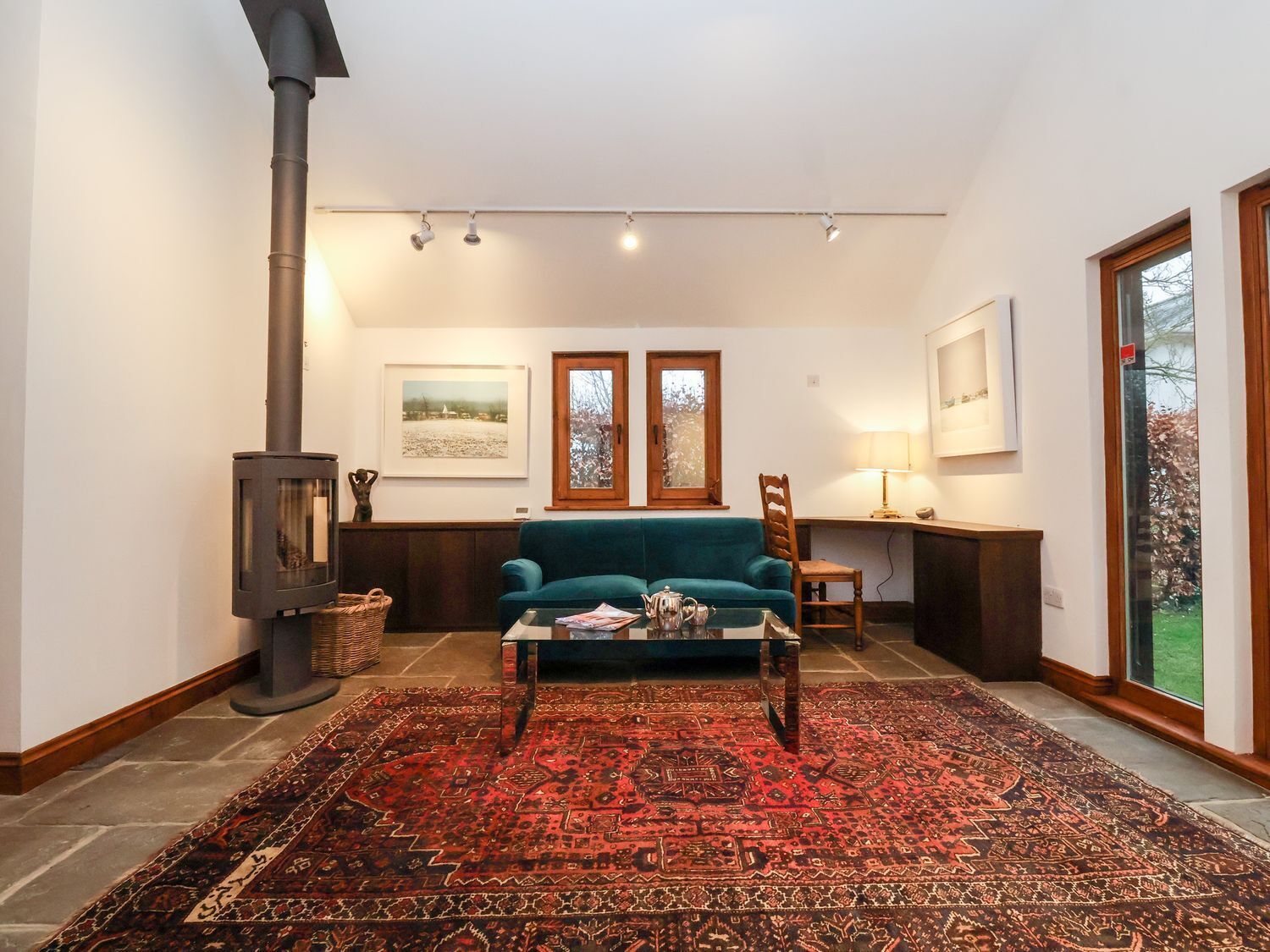 A cozy living room with a sofa, a coffee table, a fireplace, and a rug.