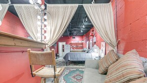 A room with a bed, a chair, a sofa, and a patterned rug. - Cozy Single at The Strand (Waynesville)