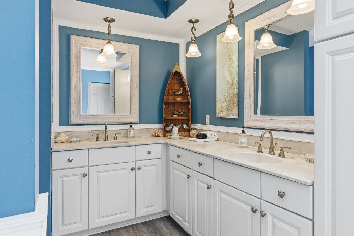 A bathroom with two sinks, white cabinetry, and a large mirror.
