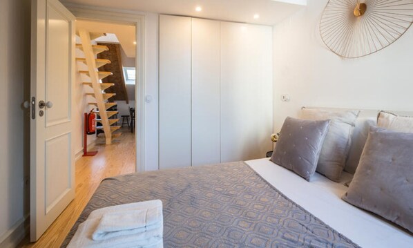 Tabla de planchar con plancha y ropa de cama
