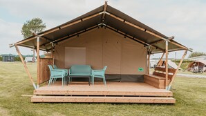 A tent with a wooden deck, two chairs, and a table. - Safari Tent Blossom Lodge (Kesteren)