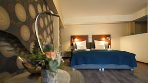 Habitación de hotel con cama, mesita de noche, lámpara y decoración en la pared.
