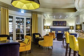 A modern hotel lobby with a seating area, a bar, and a bookshelf. - Dorint Parkhotel Meissen (Nossen)