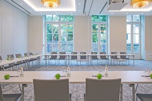 A conference room with long tables, chairs, and green apples on each table. - Dorint Parkhotel Meissen (Nossen)