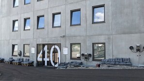 Un edificio con un cartel grande con el número 40, varias ventanas y una zona de estar exterior con cojines.