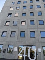 Un edificio moderno con un gran letrero con el número 40, numerosas ventanas y una entrada de vidrio.