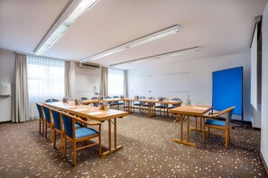 A conference room with a long table, blue chairs, and a projector screen. - Best Western Hotel Erlangen (Erlangen)