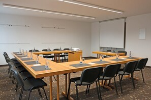 A conference room with long tables, black chairs, and a whiteboard. - Best Western Hotel Erlangen (Erlangen)