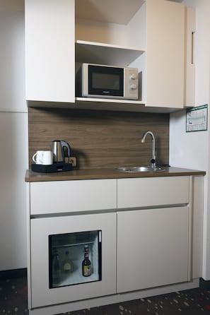 A compact kitchenette with a microwave, kettle, and sink. - Best Western Hotel Erlangen (Erlangen)