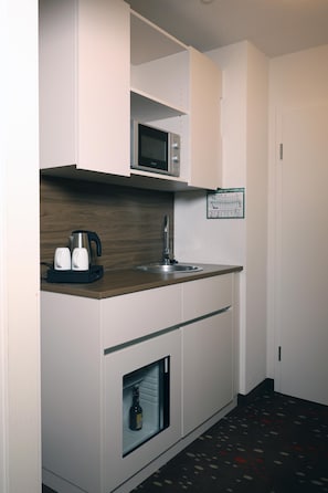 A compact kitchenette with a microwave, kettle, and coffee maker, a sink, and a wine cooler. - Best Western Hotel Erlangen (Erlangen)