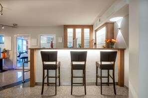 A bar area with three stools, a wooden counter, and a frosted glass partition. - Best Western Hotel Erlangen (Erlangen)