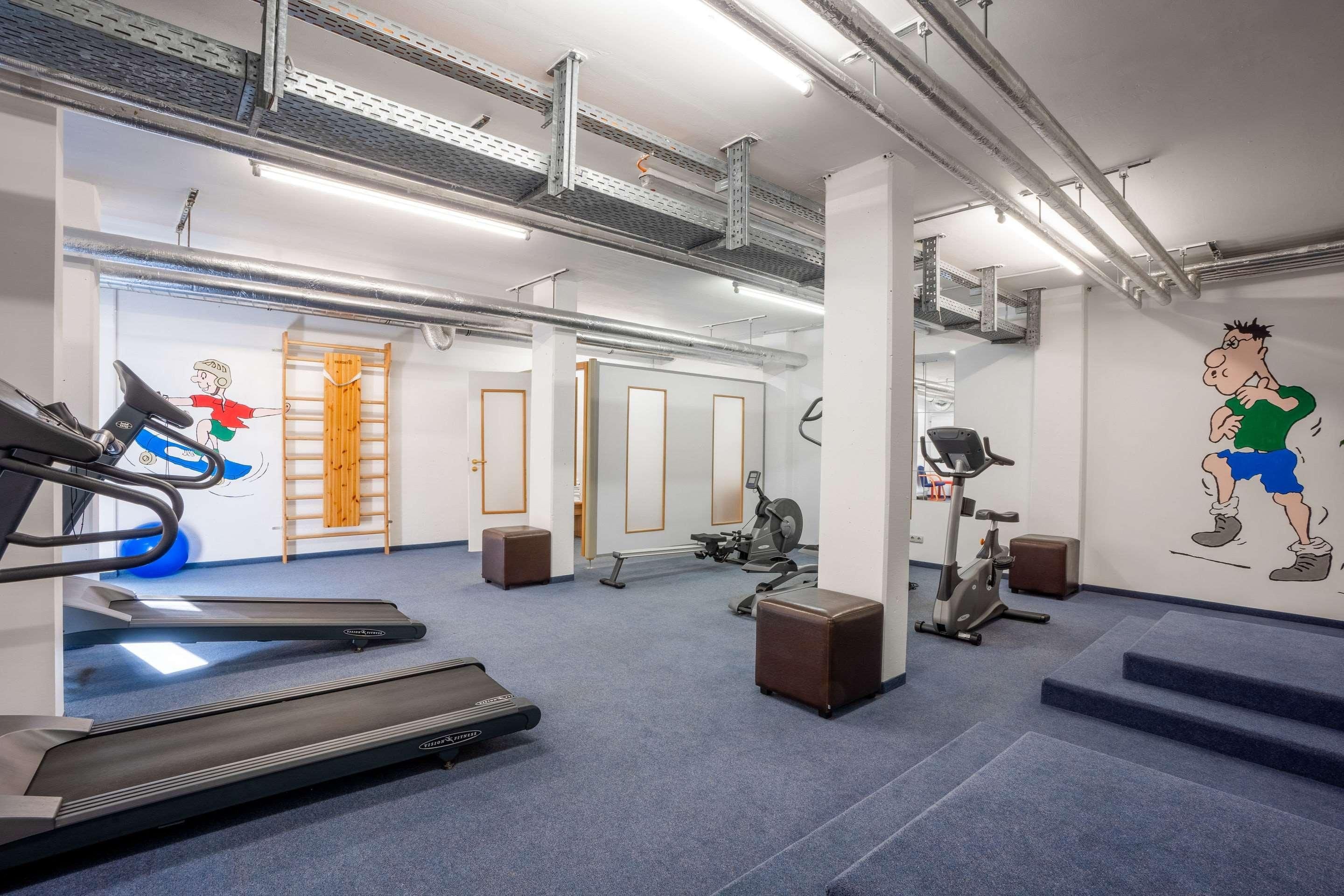 Ein Fitnessraum mit Laufbändern, Ergometer und Rudergerät.