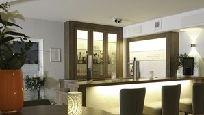 A modern kitchen with a bar area, a dining table with chairs, and a potted plant. - Best Western Hotel Erlangen (Erlangen)