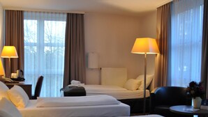 A hotel room with two beds, a desk, a chair, and two lamps. - Best Western Hotel Erlangen (Erlangen)