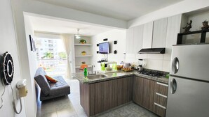 Une cuisine moderne dotée de plans de travail en granit, d’appareils électroménagers en acier inoxydable et d’armoires en bois.
