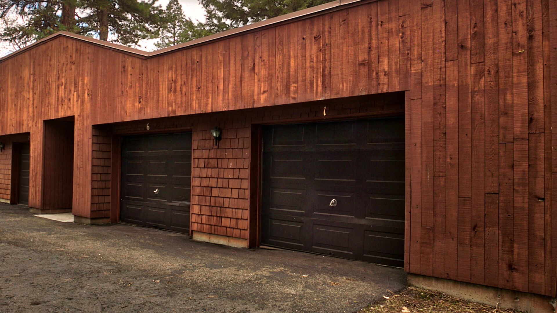Un bâtiment avec trois portes de garage et un mur en briques.