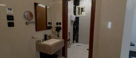 Une salle de bain moderne avec un meuble-lavabo, un miroir et un espace douche.