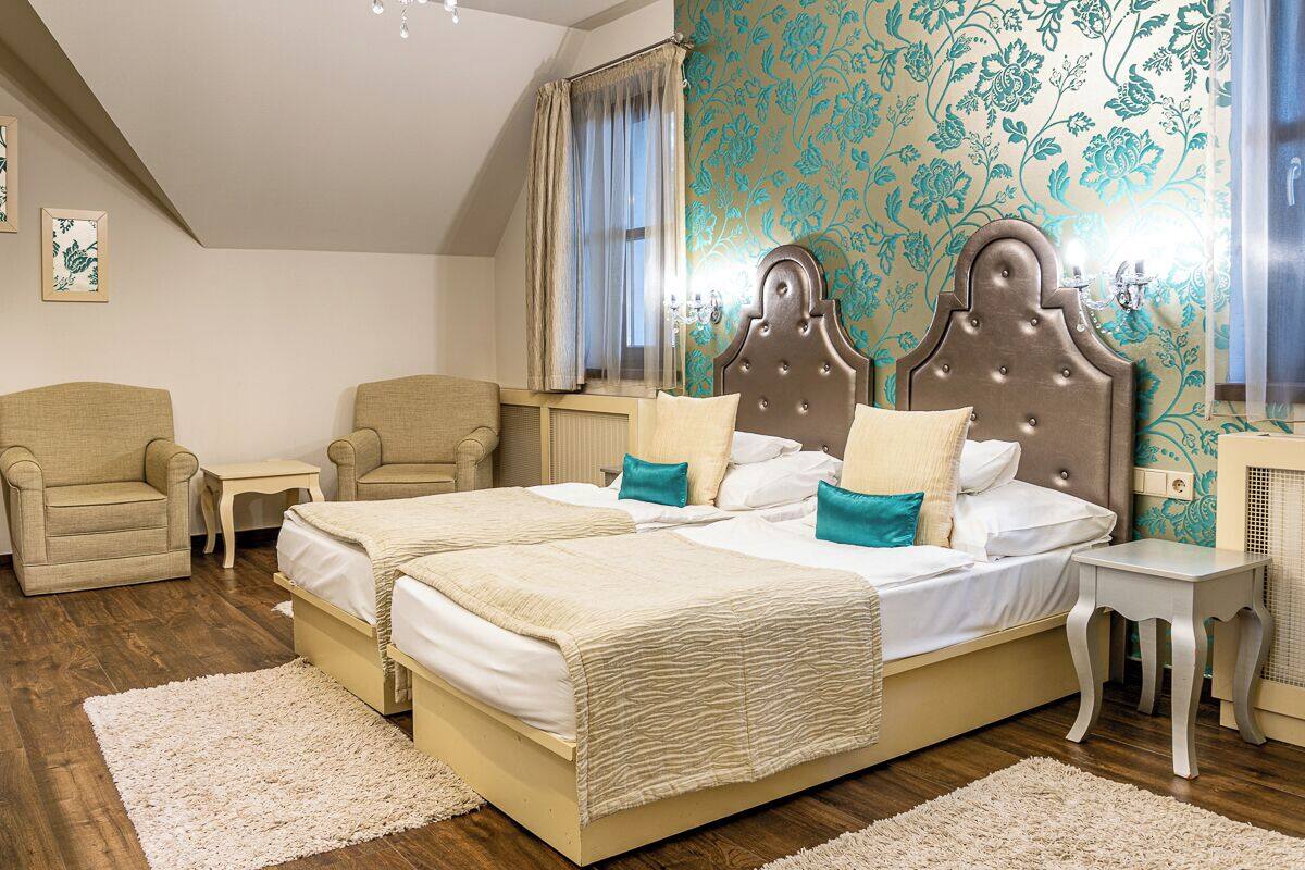 A double bed with a headboard, two bedside tables, and a chair.