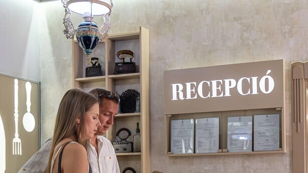 A reception area with a sign reading "RECEPCIÓN" and a woman holding a tablet. - Varga Tanya Hotel, Konferencia és Szabadidő Központ (Kerekegyháza)