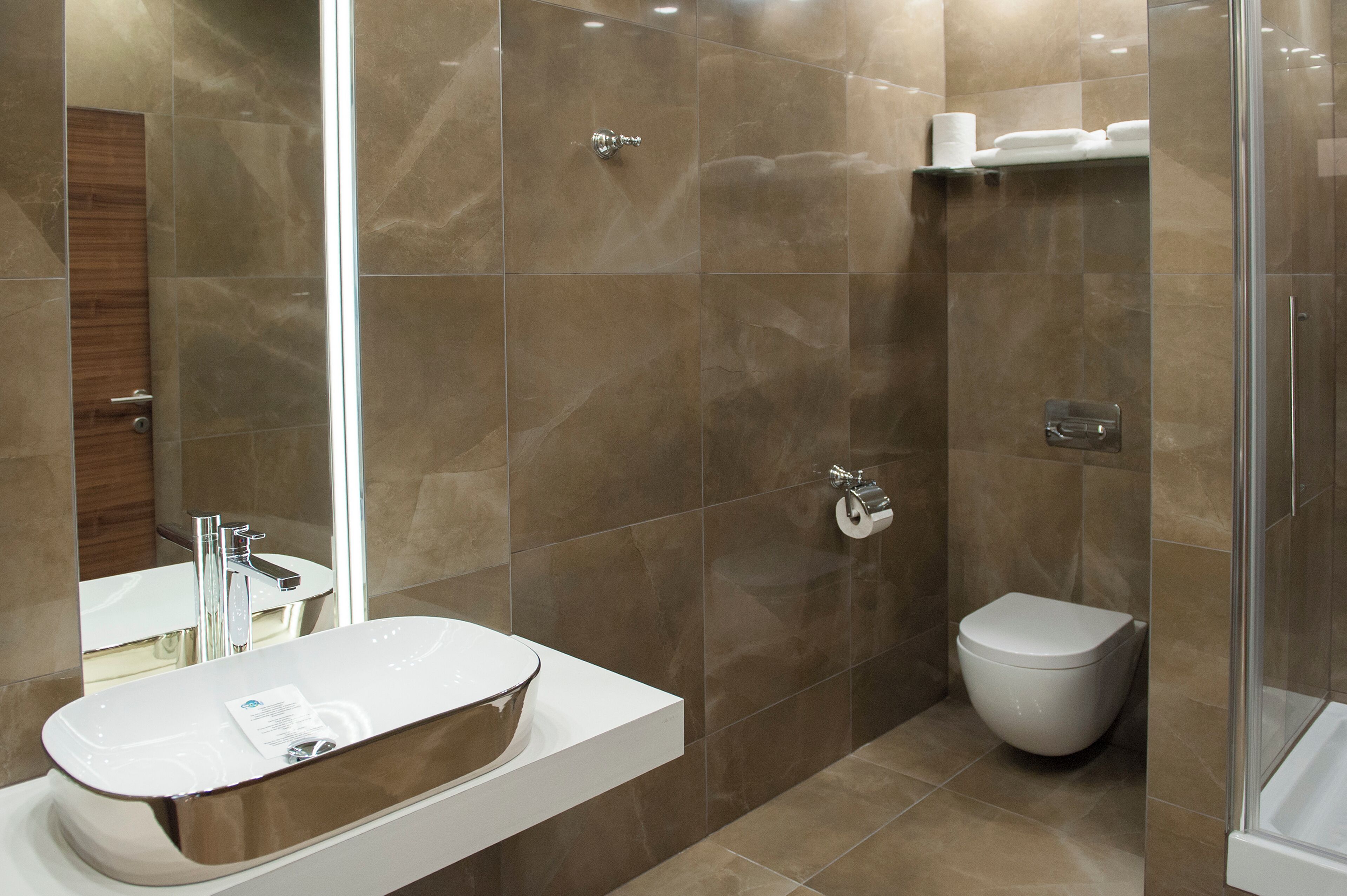 Un baño moderno con un lavamanos grande, un inodoro y una zona de ducha.