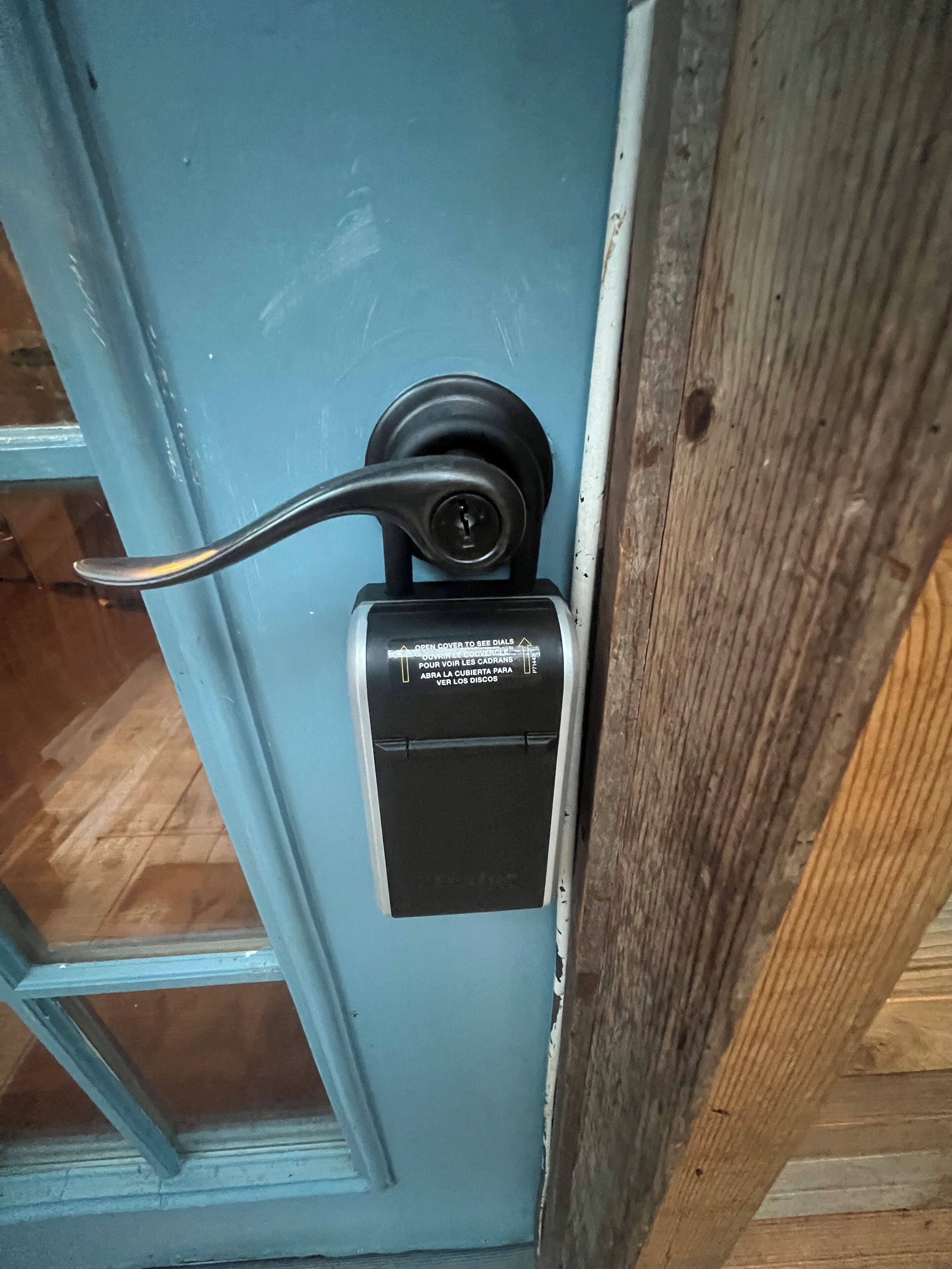 Una porta con un citofono nero e una maniglia in metallo.