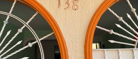 A building entrance with two large arched windows, a number '138' above the windows, and a security keypad below.