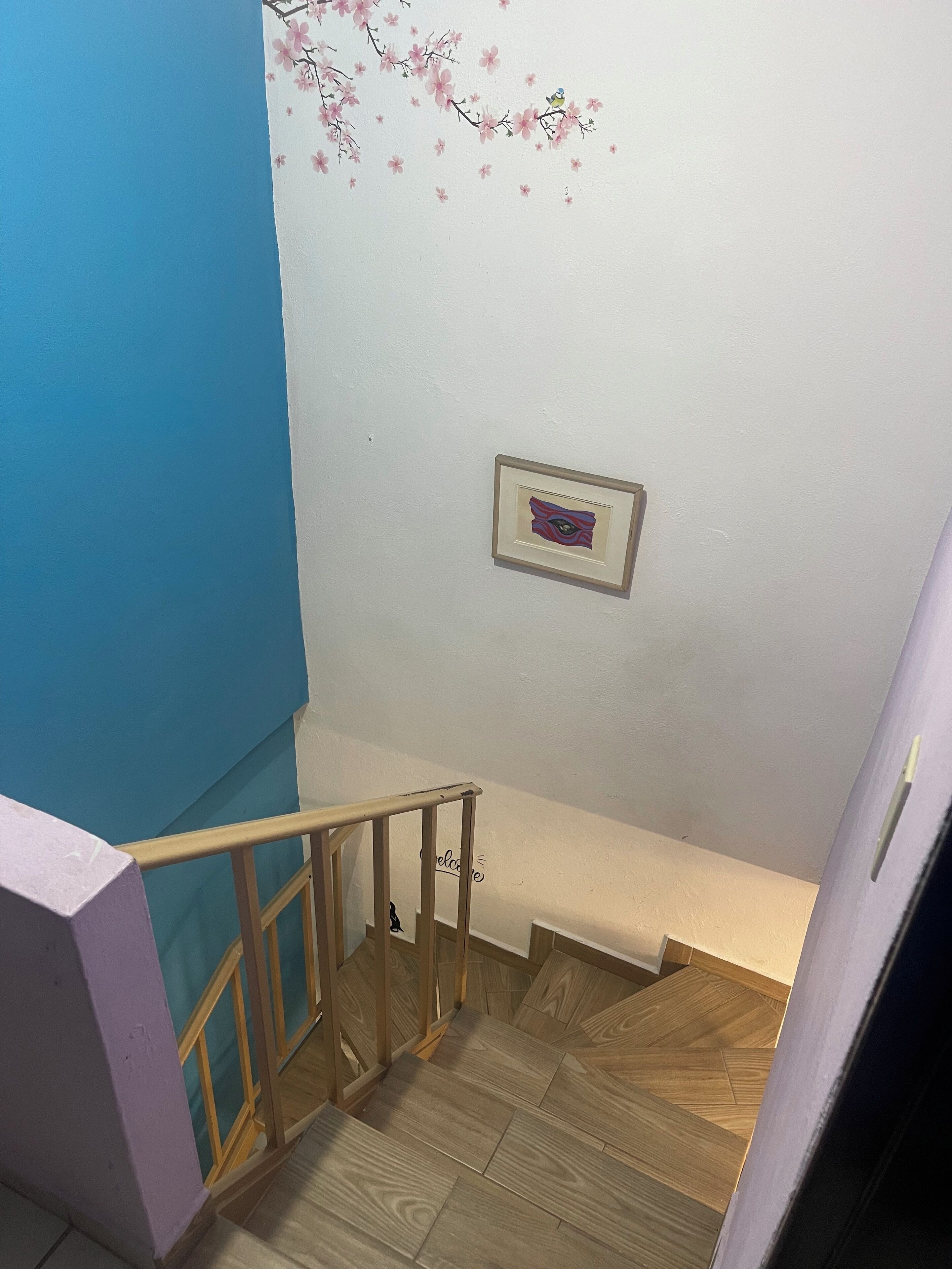 A staircase with wooden railings and a blue wall.