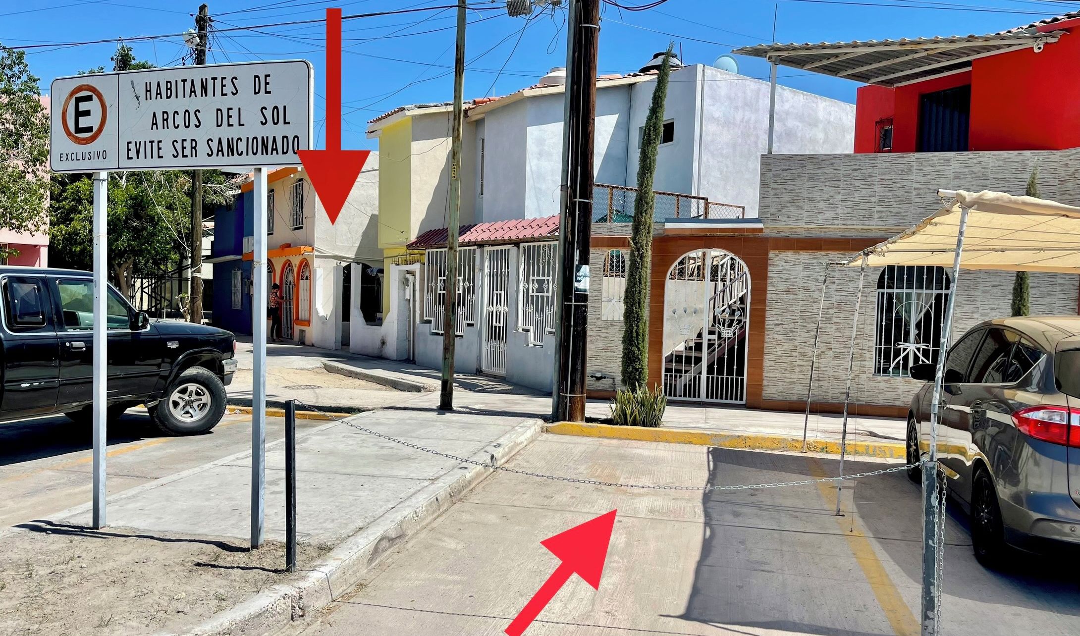 Escena de calle con un letrero que indica 'Casa Canoa' y 'Estacionamiento'.