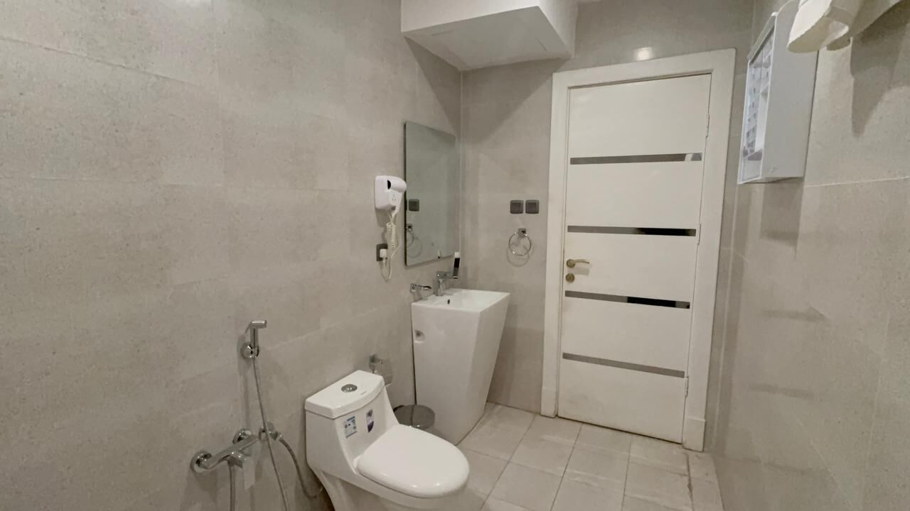 Un baño con inodoro, lavamanos y ducha.