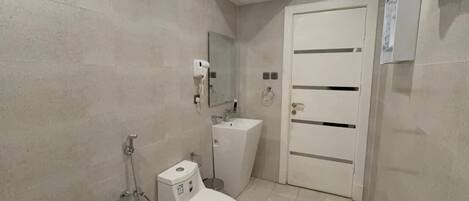 Un baño con inodoro, lavamanos y ducha.