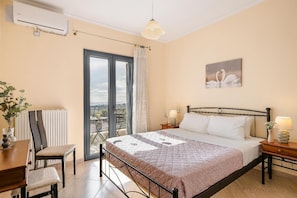Een slaapkamer met een bed, nachtkastjes, een stoel, een radiator, een raam met uitzicht en een plafondlamp.