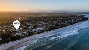 Vista aérea de Jervis Bay, con una playa, casas y cielo despejado.