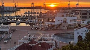 A marina with boats docked, a bridge in the background, and a building with a sign that reads "RESTAURANT". - Silken Turcosa 3 Sup (Castelló de la Plana)
