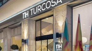 L’extérieur de l’hôtel NH Turcosa se distingue par son entrée imposante, ses portes vitrées et un balcon agrémenté de rampes en métal.
