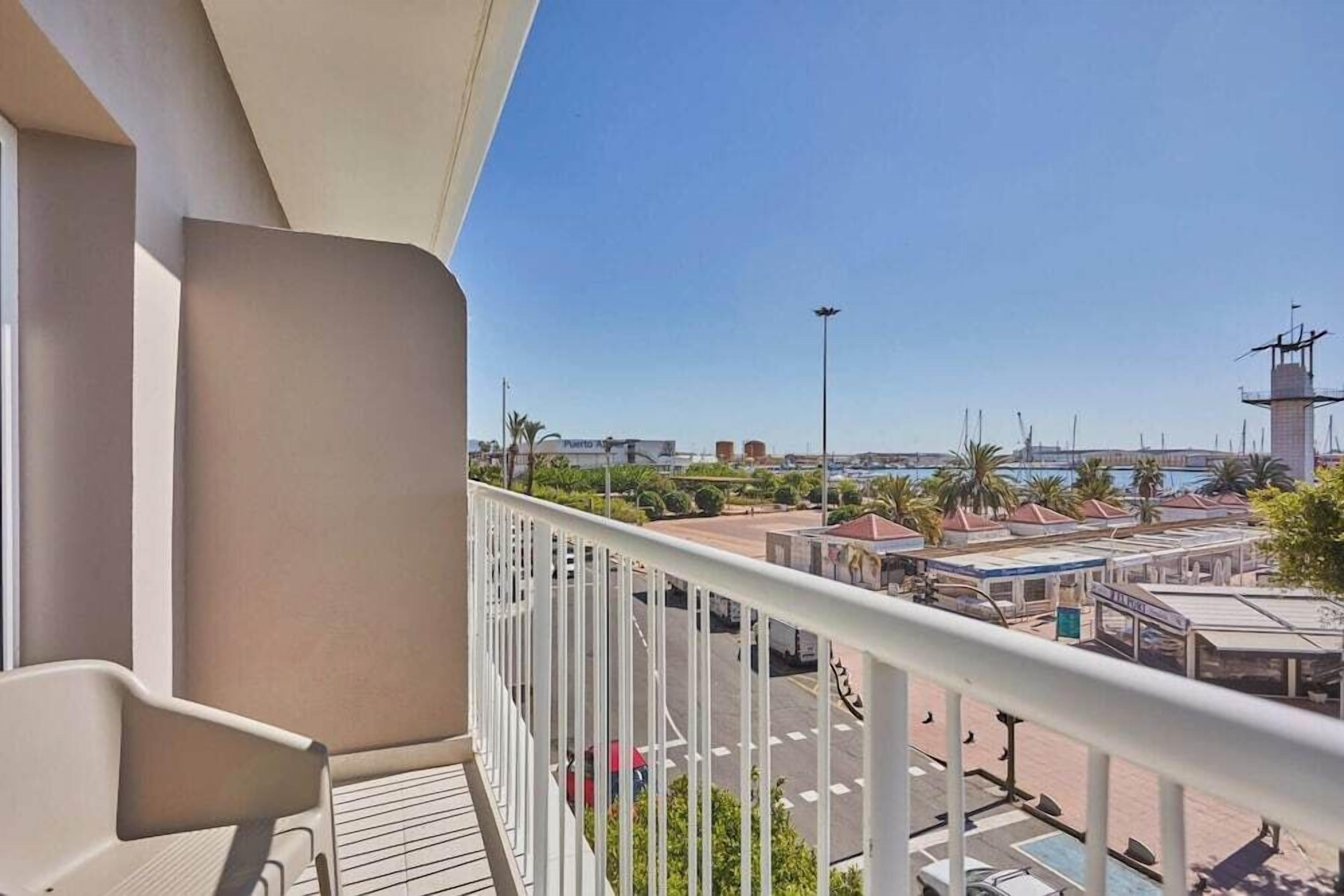 Uma varanda com vista para uma marina, incluindo barcos e um farol.