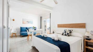 Una habitación de hotel con cama, escritorio, silla y sofá.