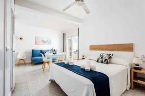 Una habitación de hotel con cama, escritorio, silla y sofá.