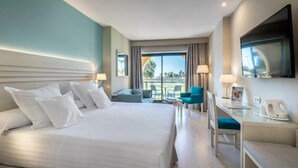 A hotel room with a large bed, a desk with a chair, a TV, and a view of the outdoors. - Barcelo Costa Ballena Golf & Spa (Rota)