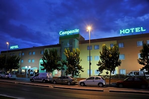 A hotel with a prominent 'Campanile' sign, multiple windows, and a parking lot with cars. - Hotel Campanile Murcia (Murcia)