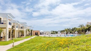 A resort with multiple buildings, a swimming pool area, and a well-maintained lawn. - Bimbolla Apartaments (Sant Lluis)