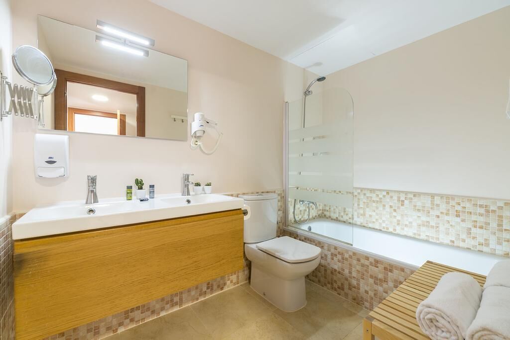 A bathroom with a sink, toilet, and shower.